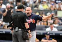 Braves Hold Steady At No. 4 Despite Home Slump Baseball coach in a navy Atlanta uniform shouting and pointing toward the umpire during a game, crowd blurred in the background.