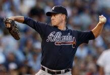 Braves Legend Sends Warning Amid World Series Pursuit Baseball pitcher in a Braves uniform delivering a pitch on the mound.